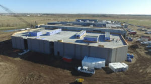 Aerial view of precast concrete building being erected with large crane to the back of the building.