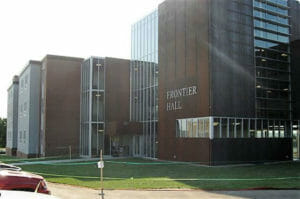 Exterior of metal building four story-building with top to bottom window paneled entrance.