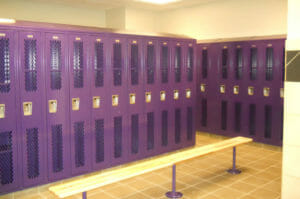 Purple locker room at New Town High School with wooden bench seat in foreground.