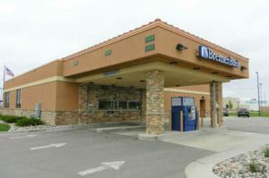 Outside concrete and stone awning covering bank teller drive-ups stations.