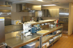 Stainless steel kitchen appliances with stainless steel counter workstations and cabinetry throughout.