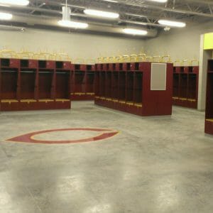 Maroon and Gold sports lockers with concrete floor and C for Concordia logo underneath.