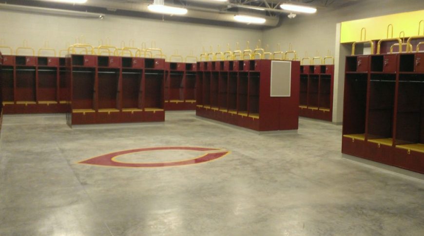 Maroon and Gold sports lockers with concrete floor and C for Concordia logo underneath.