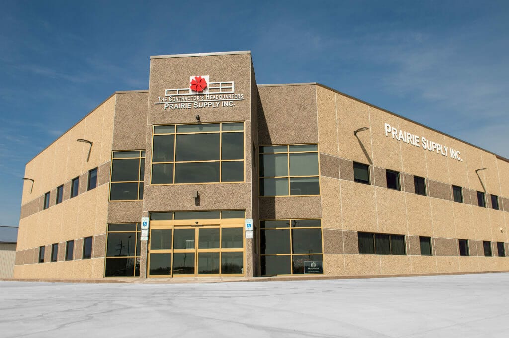 Exterior view from parking lot of Prairie Supply Inc. precast beige 2-story building.