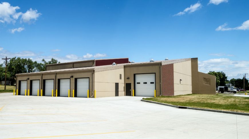 Exterior view of 9 of the vocational school garage entrances from the concrete parking lot.