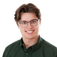 White male in 20's with brown hair and glasses in green button-up shirt on white background