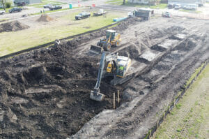 Aerial view of construction Equipment digging on empty city lot