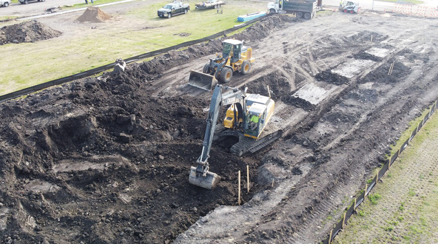 Aerial view of construction Equipment digging on empty city lot