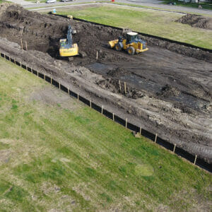 Aerial view of construction Equipment digging on empty city lot