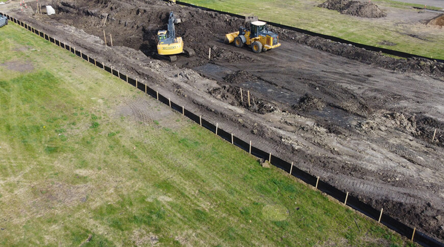 Aerial view of construction Equipment digging on empty city lot