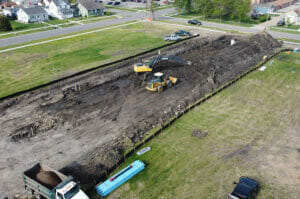 Aerial view of construction Equipment digging on empty city lot