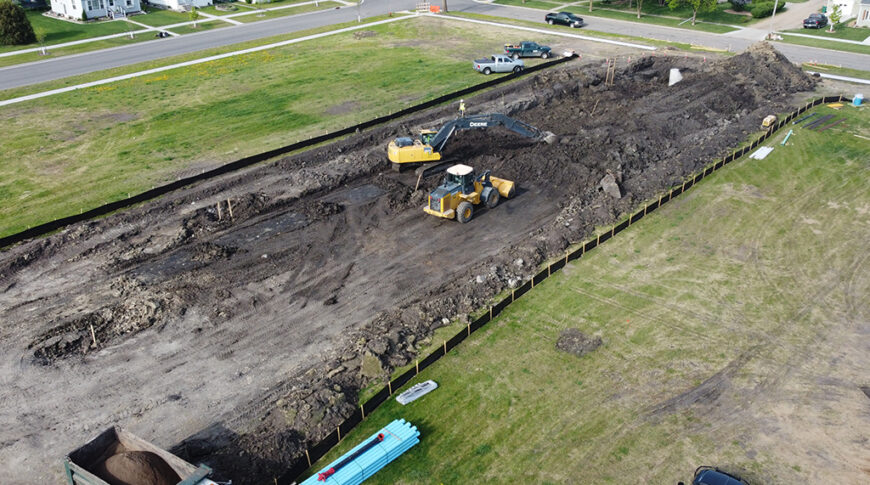 Aerial view of construction Equipment digging on empty city lot