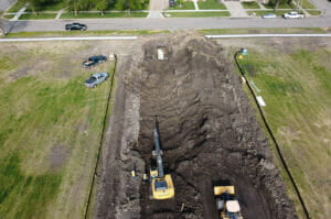 Aerial view of construction Equipment digging on empty city lot