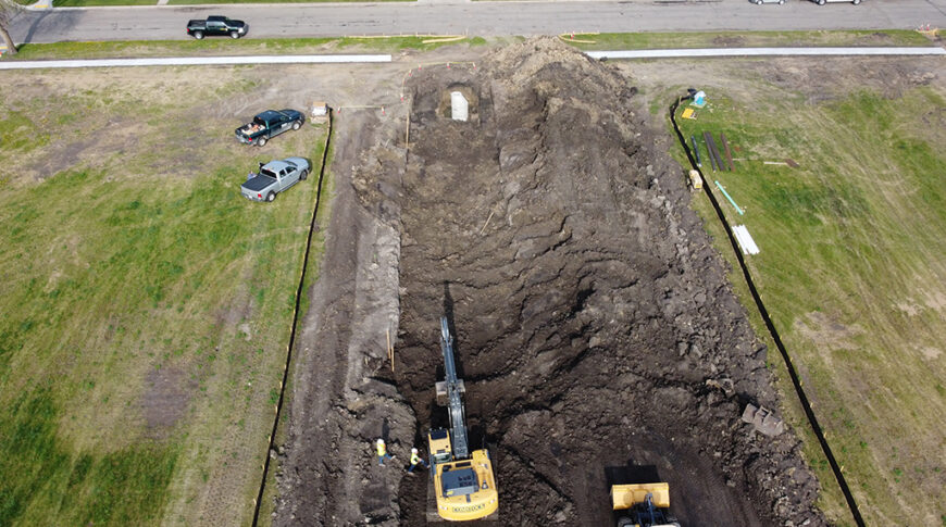 Aerial view of construction Equipment digging on empty city lot