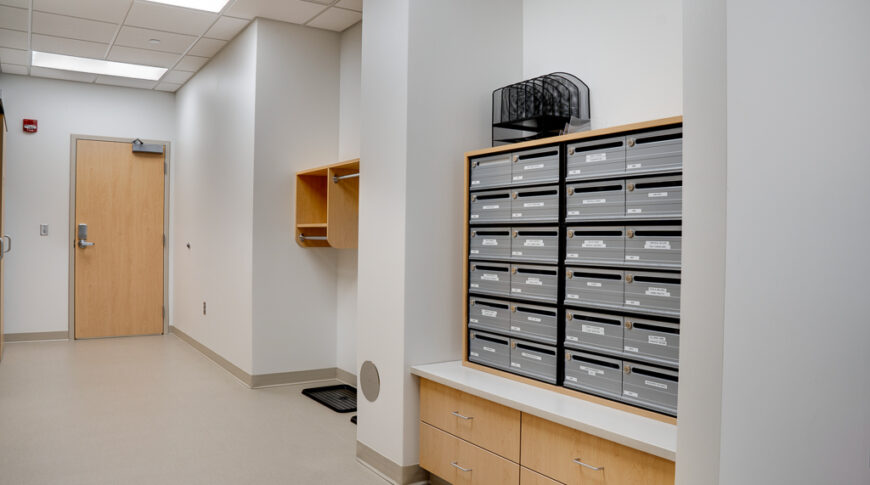 Back hallway with oak cabinetry and doors with organizational cubbies.