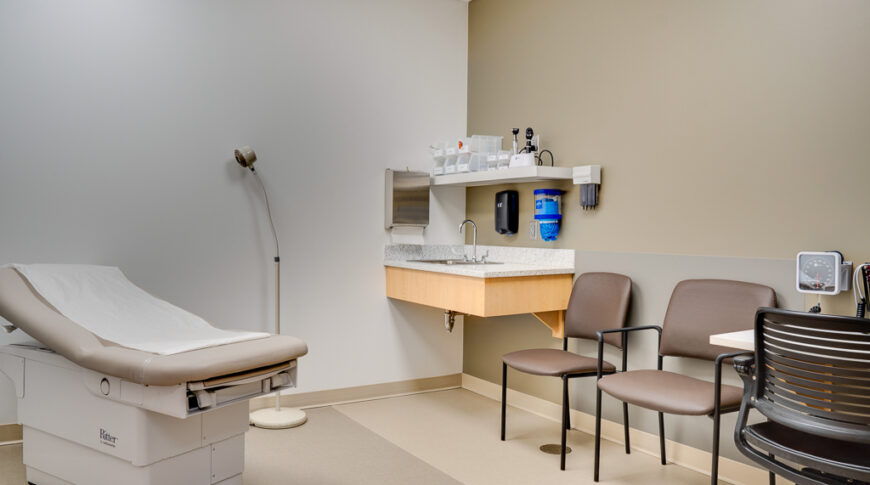 Exam room with exam table, three chairs.