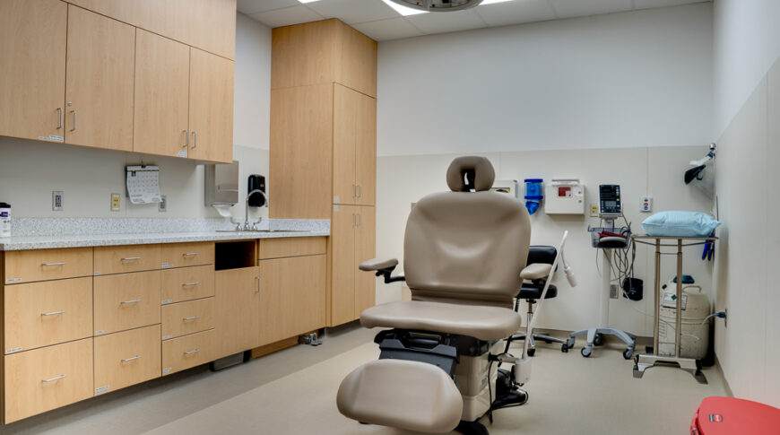 Procedure room with procedure chair and white oak cabinetry.