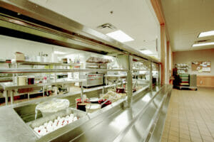 Project Turnabout commercial kitchen with pass-through window to tiled dining hall.