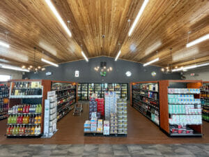 Cenex C-Store liquor store viewpoint in front of isles looking down the rows of liquor with coolers in the background and pine wooden planked vaulted ceiling overhead.