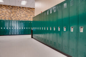 School hallway intersection with green lockers on each wall.