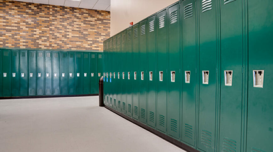 School hallway intersection with green lockers on each wall.
