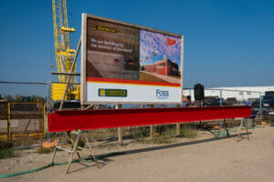 Red construction beam on two saw horses with Vaderstad Construction sign in background.