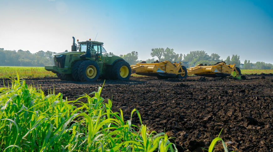 City of Horace-Civil Construction-Low Res-4 Tractor with scraper attachment working on grading a dirt field that will be the new site of the rivers edge second addition.