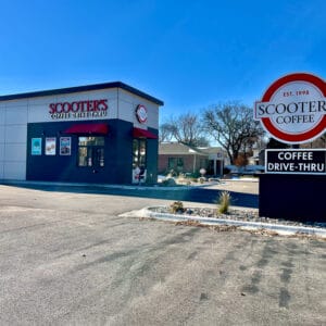 Exterior view of Scooter's Coffee sign and building from the parking lot during late fall.