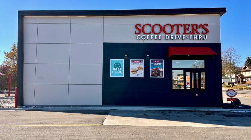 Side view of Scooter's coffee drive-thru window with black and taupe walls with red awning and accents.
