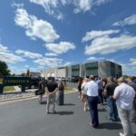 FMWF Chamber of Commerce representatives and Comstock Construction employees stand outside Comstock Construction's Fargo office location for a rebar-cutting event.