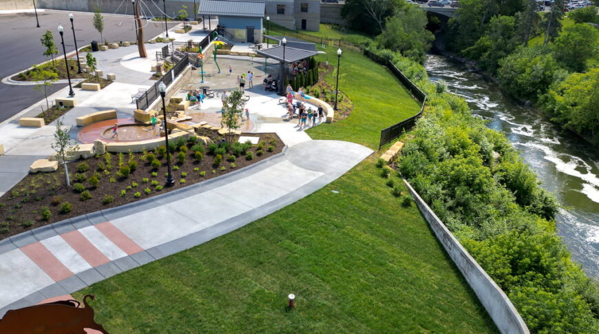 Aerial drone view from the west side of the Fergus Falls Riverfront Splash Pad with the Otter Tail river in the background.