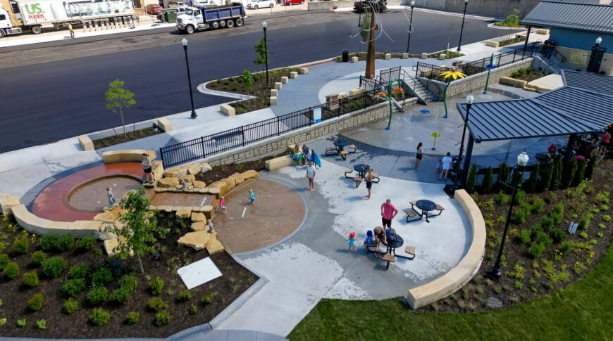 Aerial drone view from the west side of the Fergus Falls Riverfront Splash Pad with the Otter Tail river in the background.