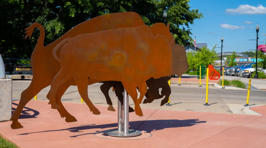 Custom bike rack made from orange rust-colored metal shaped as bisons.