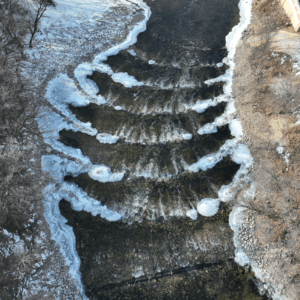 Aerial view of the rock weirs in the Sheyenne River with riverbanks on either side.