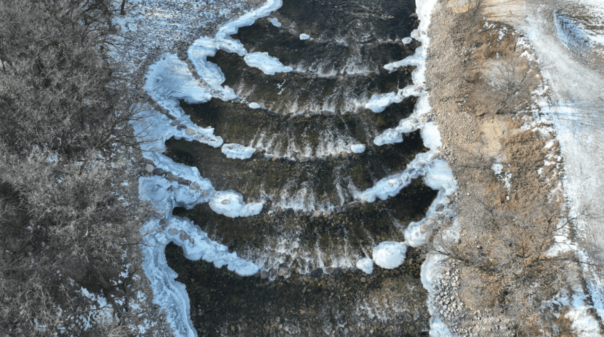 Aerial view of the rock weirs in the Sheyenne River with riverbanks on either side.