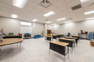Brand new classroom building with modern flooring and tiled ceiling and beige walls.