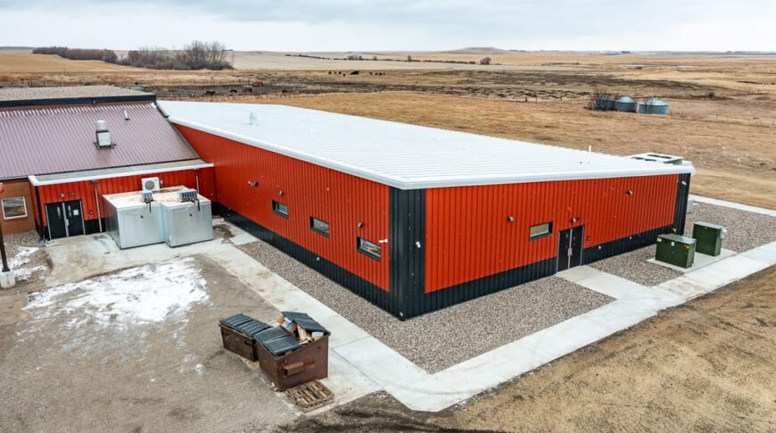 Exterior aerial view of the new Selfridge Public School addition that's clad in bright orange and dark gray metal siding.