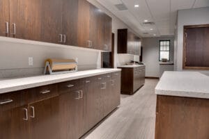 Dark-stained cabinetry running the length of the office hallway with a peek of one of the original building windows to the back.