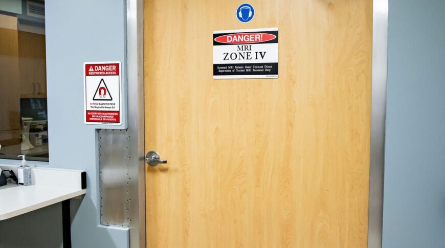 Doorway into the MRI room. It has a mat underneath with lots of cautionary symbols and info as well as a large sign on the door.