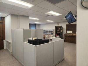 Courthouse office cubicle area with security screen on upper right wall.