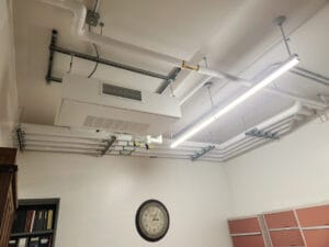 Ceiling office backroom with exposed mechanical and electrical piping.