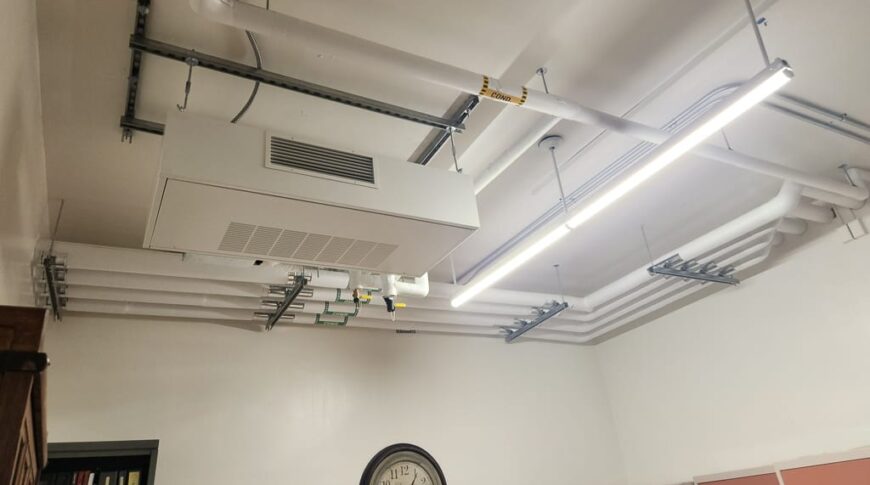 Ceiling office backroom with exposed mechanical and electrical piping.