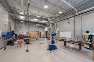 Large workshop with tall ceilings of exposed metal trusses at Dunseith CTE center. Photo by Icon Architectural Group.