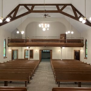 After view from the pulpit looking over rows of pews and choir loft remodeled with new flooring and paint.