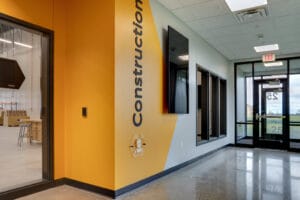 Bright yellow painted wall with the words "Construction" and a door to enter the construction wing at NDSCS Career Innovation Center.