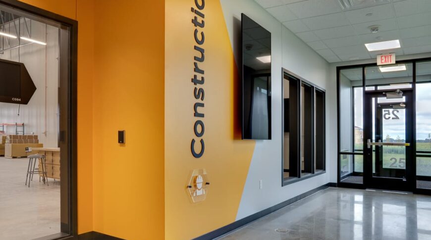 Bright yellow painted wall with the words "Construction" and a door to enter the construction wing at NDSCS Career Innovation Center.