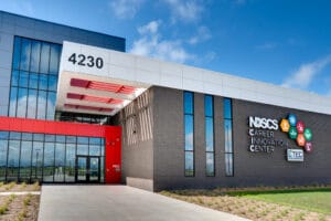 Exterior entrance of NDSCS Career Innovation Center building. A mix of brick facade to the left, and bright red paneling to the right.