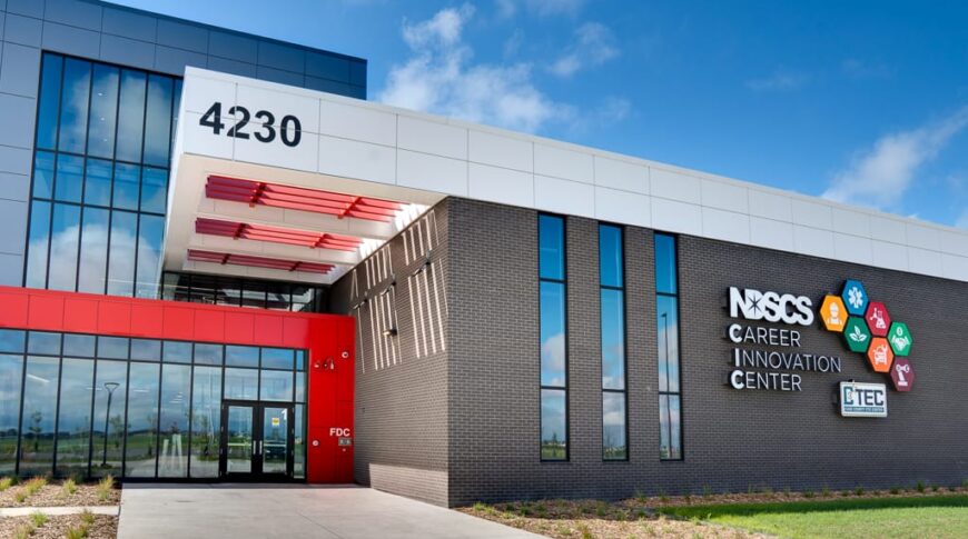 Exterior entrance of NDSCS Career Innovation Center building. A mix of brick facade to the left, and bright red paneling to the right.