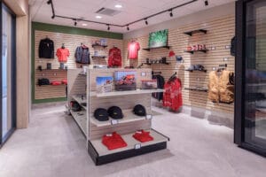 Company clothing store with wood slat display panels and green accent walls in Vaderstad colors.