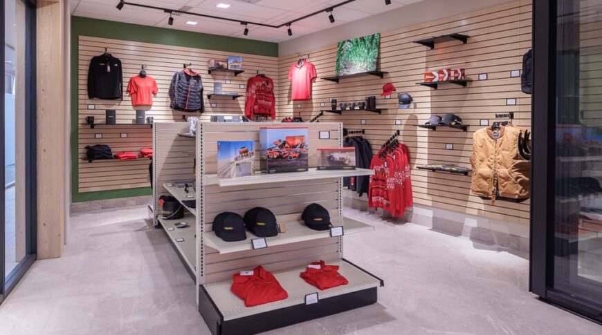 Company clothing store with wood slat display panels and green accent walls in Vaderstad colors.